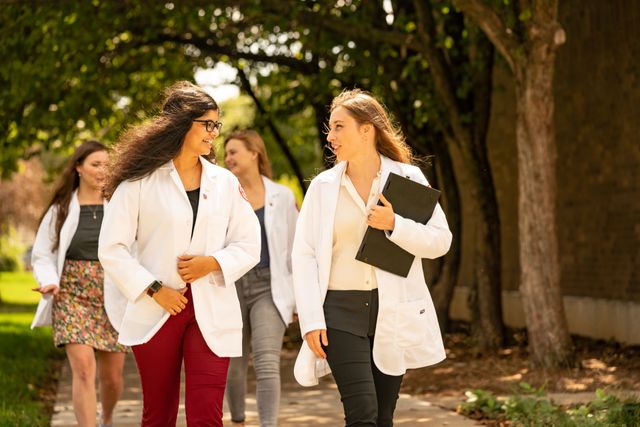 Two Aequitas Health fellows discussing a community health initiative between classes